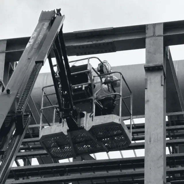 Trabajo en altura sobre estructura metálica con plataforma elevadora.